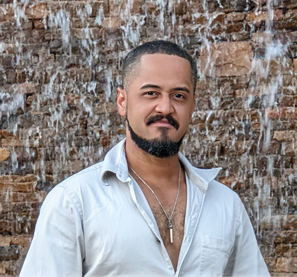 Real photograph of Sensei Stan beside a textured stone wall